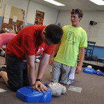 Kids performing CPR on dummy at Algoma Christian